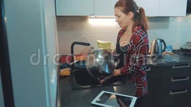 女孩在厨房砧板上洗碗。 女人在厨房做饭。 女孩在生活方式上洗了一把刀